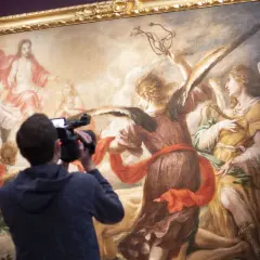 Un hombre graba con una cámara una obra de Juan de Valdés Leal, que representa a ángeles y a Jesucristo en el cielo.