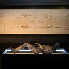La sabana santa de Turín, con la imagen de un hombre crucificado, se exhibe junto a una figura que representa su cuerpo.