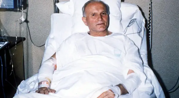 Juan Pablo II en cama de hospital, recuperándose tras el atentado. Sus brazos vendados muestran las secuelas del ataque.