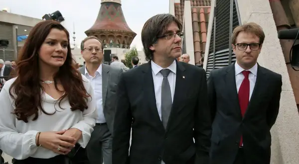 Francisco Javier Puig, con traje oscuro y corbata gris, camina junto a otros políticos.