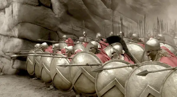 Soldados espartanos en formación, listos para la batalla de Pidna. Escudos y lanzas apuntan al frente.