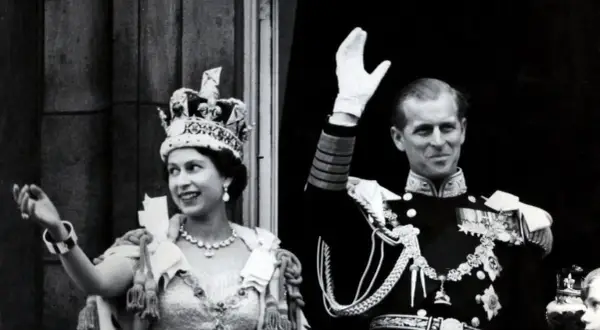La reina Isabel II, con su corona, y el príncipe Felipe saludan tras su coronación.