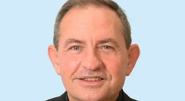 Retrato de un hombre mayor con sotana negra, sonriendo. Podría ser el párroco de San Pedro de Osma.