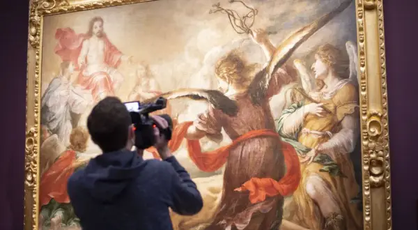 Un hombre graba con una cámara una obra de Juan de Valdés Leal, que representa a ángeles y a Jesucristo en el cielo.