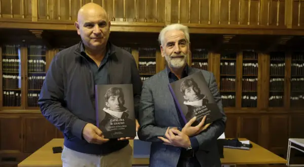 Dos hombres presentan libros sobre Catalina de Erauso, la monja alférez, en una biblioteca.
