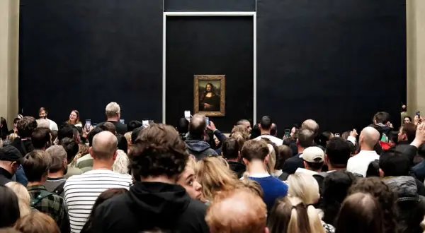 Multitud admira la Mona Lisa en el Louvre.