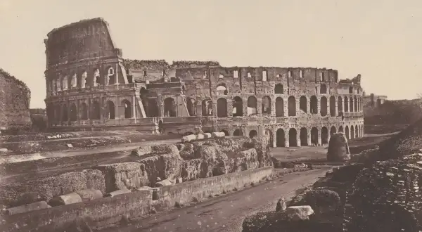 El coliseo romano antes y después: ruinas de un anfiteatro antiguo, con arcos y muros derruidos, evocando su pasado glorioso.