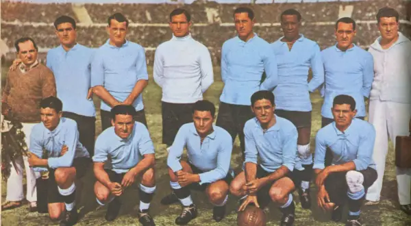 Equipo de Uruguay posa antes del primer mundial de futbol. Jugadores con camisetas celestes y un entrenador.