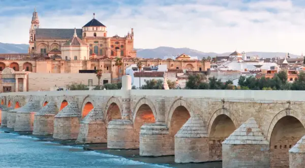 El Puente Romano cruza el Guadalquivir hacia la Mezquita de Córdoba, un monumento histórico.