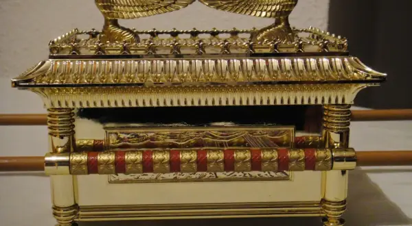 Réplica dorada del arca de la alianza, con querubines alados en la tapa y detalles ornamentales.