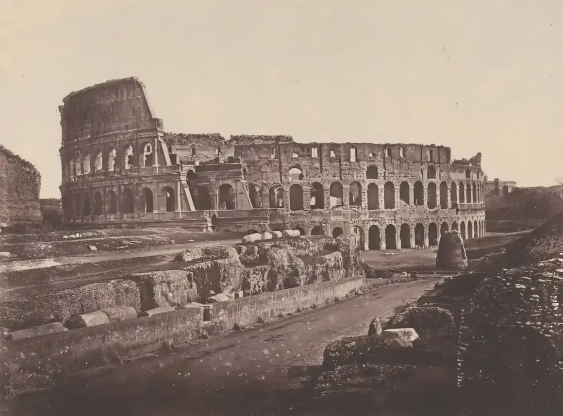 El coliseo romano antes y después: ruinas de un anfiteatro antiguo, con arcos y muros derruidos, evocando su pasado glorioso.