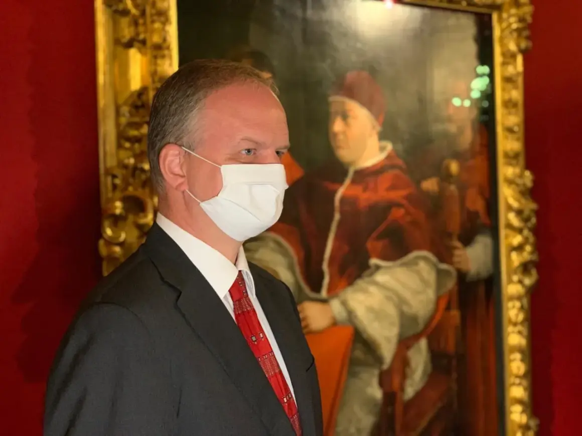 Hombre con mascarilla frente a un retrato del papa León X.