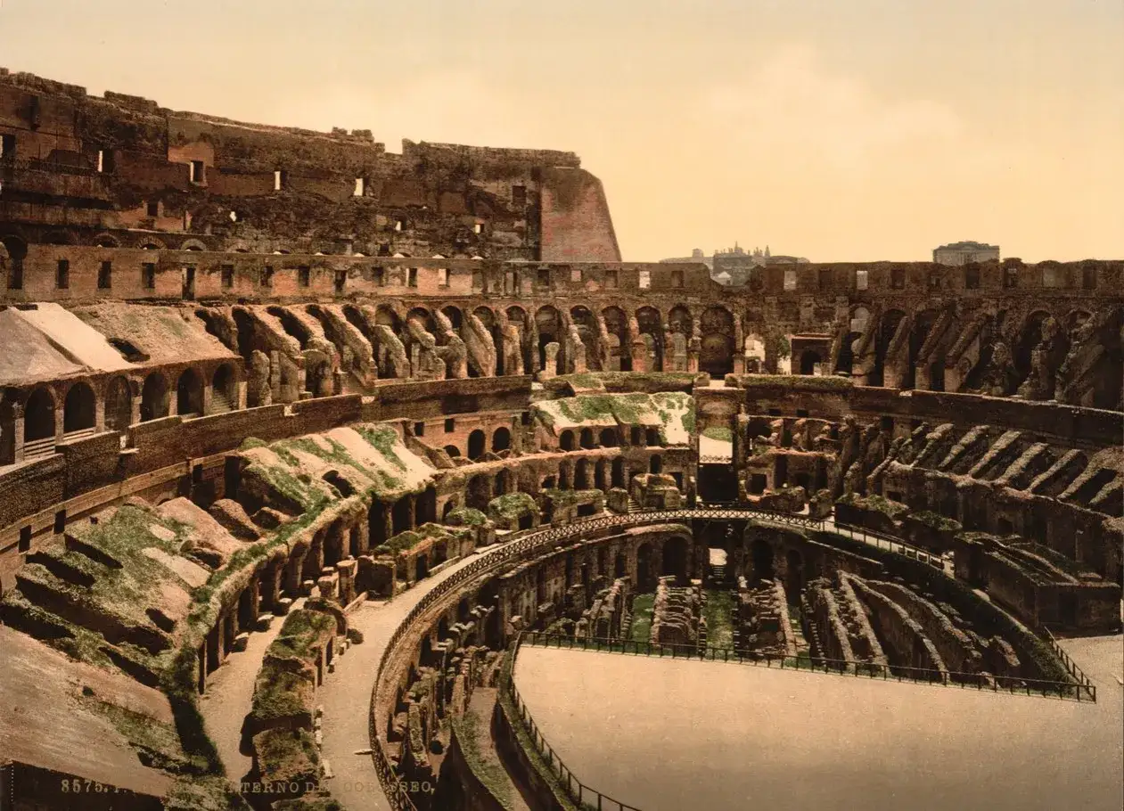 Vista interior del Coliseo Romano, con sus arcos y gradas en ruinas, evocando la grandeza del pasado.