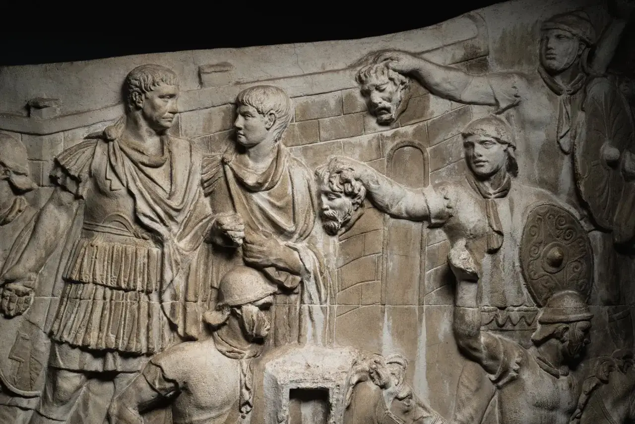 Relieve de la Columna de Trajano: soldados romanos capturan enemigos. Detalle de la historia en piedra.