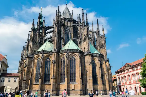 Imponente catedral gótica con sus torres y arcos detallados, bajo un cielo azul con nubes.