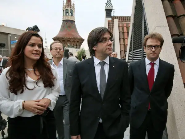 Francisco Javier Puig, con traje oscuro y corbata gris, camina junto a otros políticos.