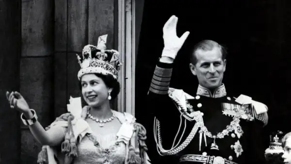 La reina Isabel II, con su corona, y el príncipe Felipe saludan tras su coronación.