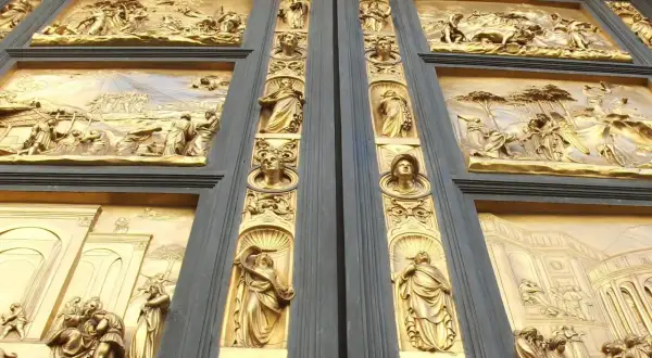Detalle de las puertas del paraíso, con relieves dorados que narran escenas bíblicas y figuras alegóricas.