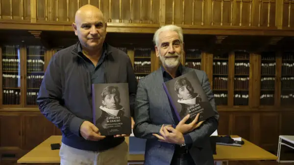 Dos hombres presentan libros sobre Catalina de Erauso, la monja alférez, en una biblioteca.