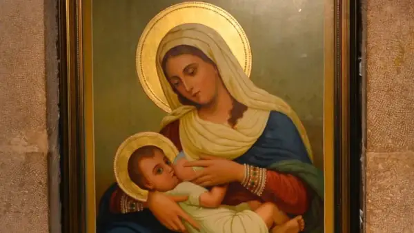 Virgen María amamantando al Niño Jesús, con halos dorados y vestimentas tradicionales.
