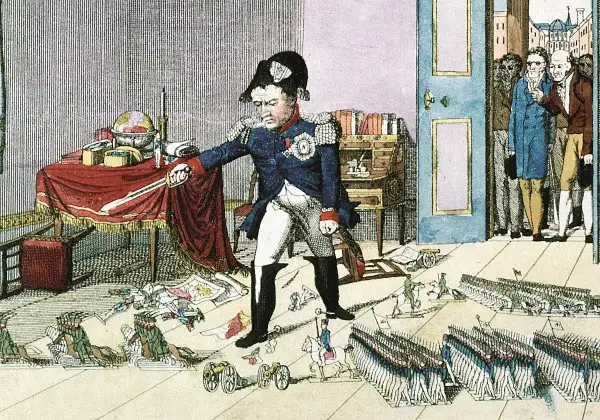 Napoleón, con su característico sombrero, parece medir su estatura en medio de un caos de mapas y soldados en miniatura.