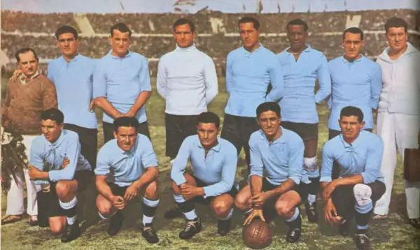 Equipo de Uruguay posa antes del primer mundial de futbol. Jugadores con camisetas celestes y un entrenador.