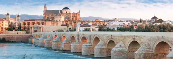 El Puente Romano cruza el Guadalquivir hacia la Mezquita de Córdoba, un monumento histórico.