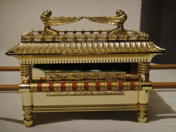 Réplica dorada del arca de la alianza, con querubines alados en la tapa y detalles ornamentales.